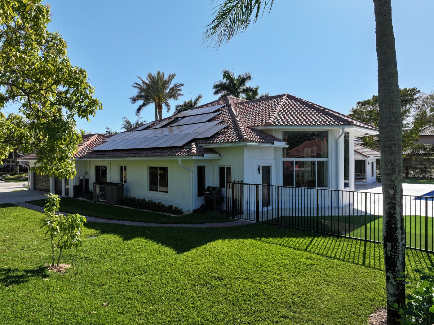 South Florida home with impact windows, tile roof, and solar panels